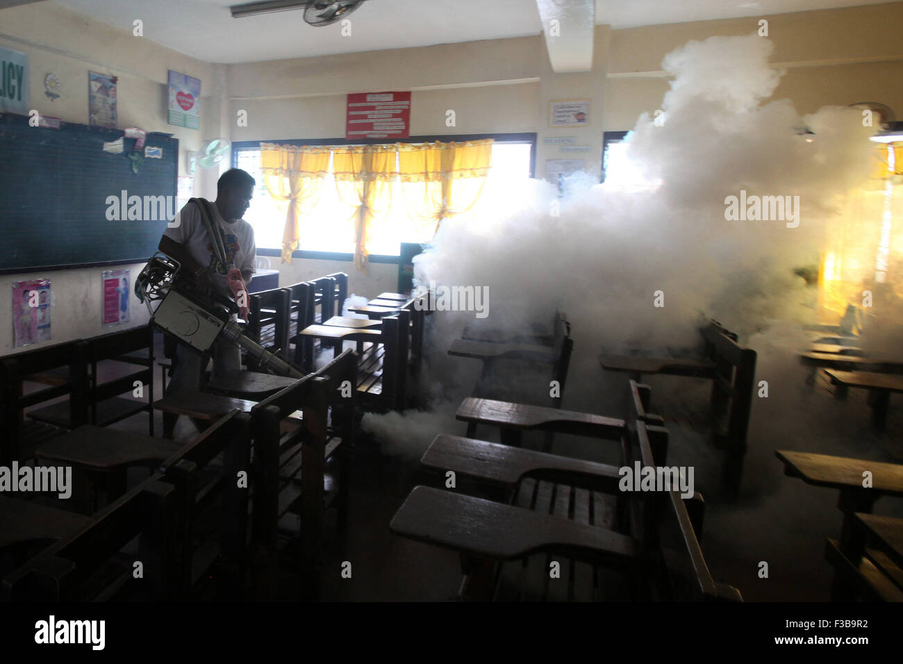 Paranaque City, Filippine. 4 Ott 2015. Un lavoratore fumigates una scuola per prevenire la diffusione della malattia di dengue in Paranaque City, Filippine, Ottobre 4, 2015. Il Dipartimento della Salute (DOH) ha registrato un totale di 78,808 casi di dengue da Gen 1 a sett. 5 questo anno, un 16,5 percento di aumento rispetto allo stesso periodo dello scorso anno. © Rouelle Umali/Xinhua/Alamy Live News Foto Stock