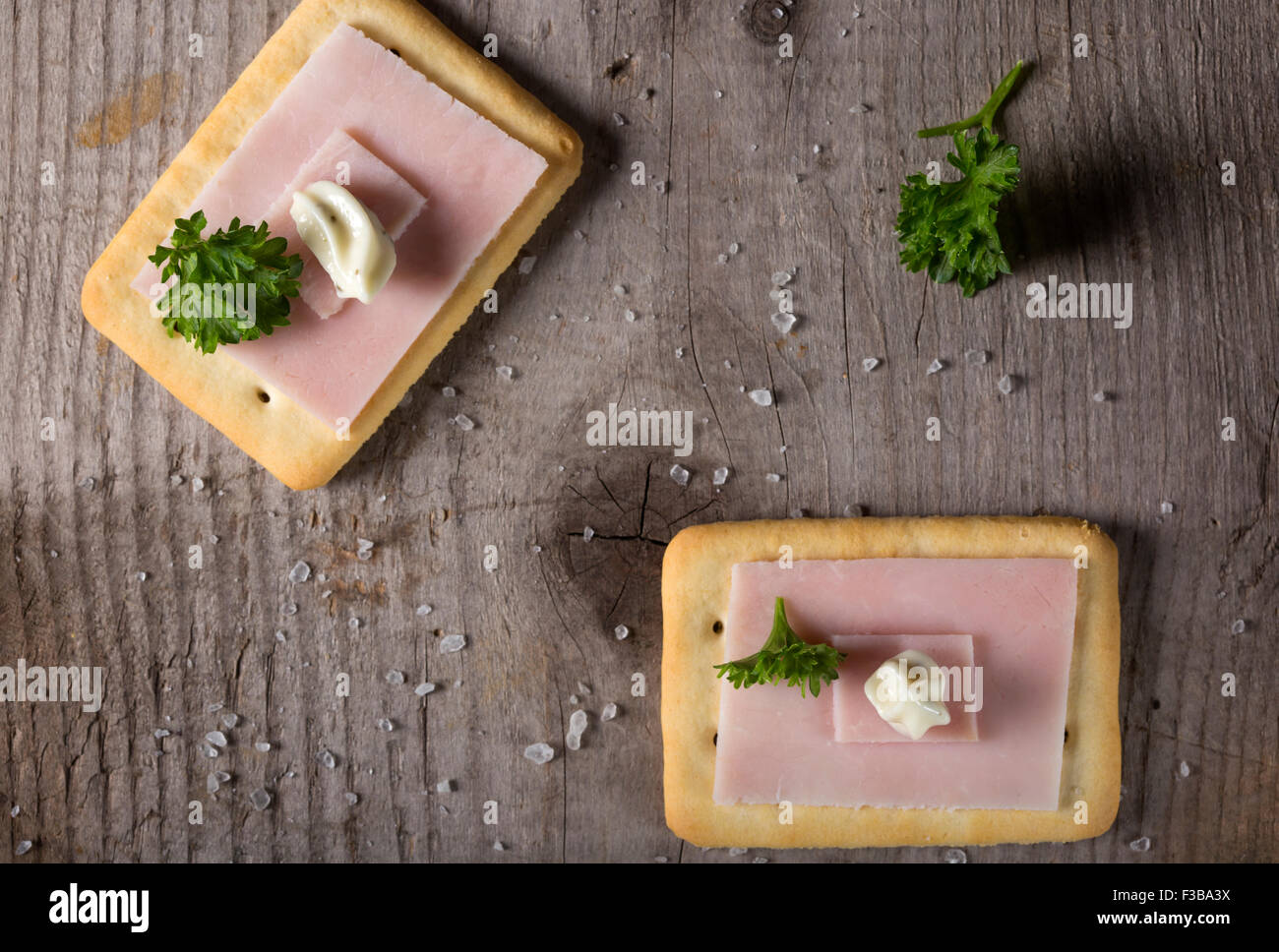 Crackers con prosciutto e salsa roumulade sul legno scuro piano portapaziente con il prezzemolo e il sale Foto Stock