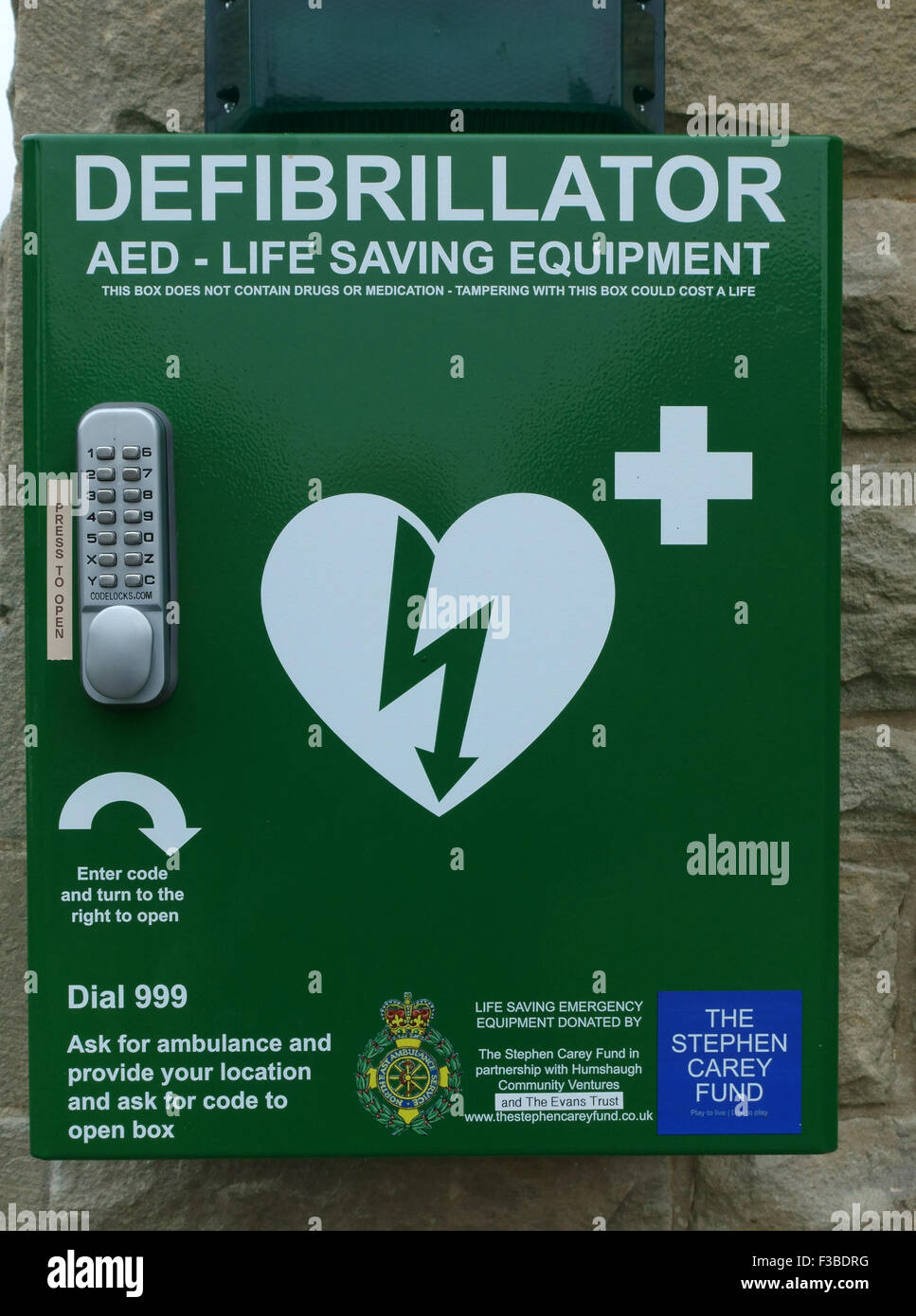 Defibrillatore attrezzature di salvataggio su village hall di Northumberland, Inghilterra Foto Stock