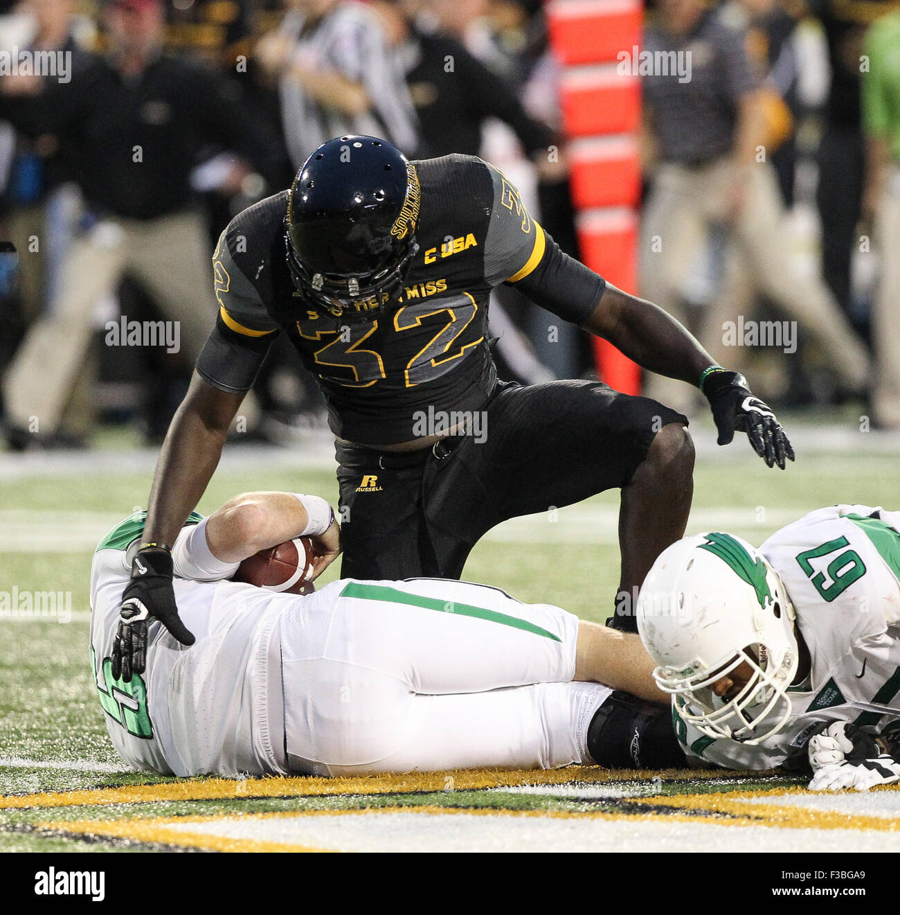 Hattiesburg MS, STATI UNITI D'AMERICA. 3° Ott, 2015. Southern Miss Golden Eagles defensive lineman Xavier Thigpen (32) affronta nord Texas verde medio quarterback Andrew McNulty (5) per una perdita durante il NCAA Football gioco tra il Southern Miss aquile reali e Nord Texas significa verde a M.M. Roberts in Hattiesburg MS. Chuck leccare/CSM/Alamy Live News Foto Stock