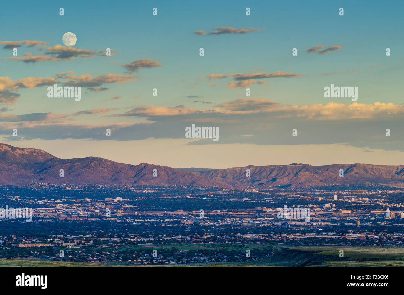 Luna piena sorgere oltre Albuquerque e Sandia Mountains, Nuovo Messico, Stati Uniti d'America. Foto Stock