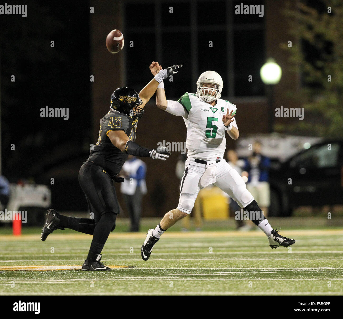 Hattiesburg MS, STATI UNITI D'AMERICA. 3° Ott, 2015. Southern Miss Golden Eagles defensive lineman LaDarius Harris (43) mettere pressione sul nord Texas verde medio quarterback Andrew McNulty (5) durante il NCAA Football gioco tra il Southern Miss aquile reali e Nord Texas significa verde a M.M. Roberts in Hattiesburg MS. Chuck leccare/CSM/Alamy Live News Foto Stock