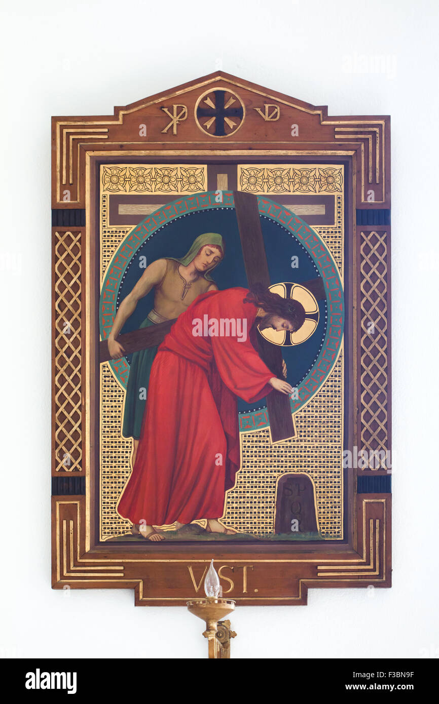 Gesù è aiutato da Simone di portare la sua croce. Dipinto di monaco benedettino Pantaleon (Jaroslav Major) dall'Beuron Scuola di Arte dal 1910s segna la quinta stazione della Via Crucis nella chiesa di San Giovanni di Nepomuk in Ceske Budejovice, Boemia del Sud, Repubblica Ceca. Foto Stock