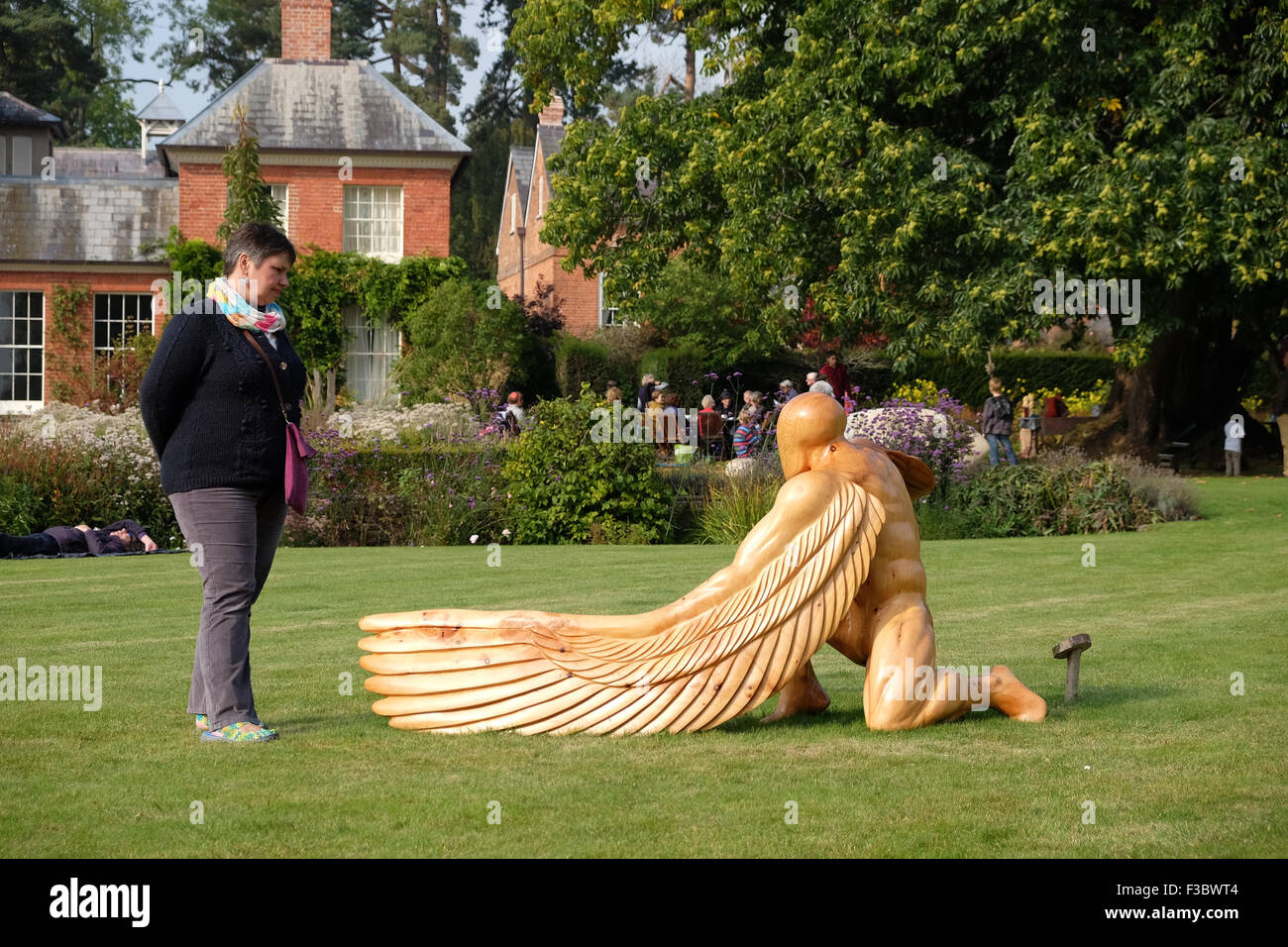 Newport House, Almeley, Herefordshire UK - Domenica 4 ottobre 2015 - Visitatori godere il giorno di apertura del fuori della natura esposizione di scultura con oltre duecento pezzi di lavoro da 40 artisti visualizzati in giardini formali di Newport House. Questo pezzo è chiamato Greer Angelo custode per artista ed Elliot e realizzata in legno di cedro. Foto Stock