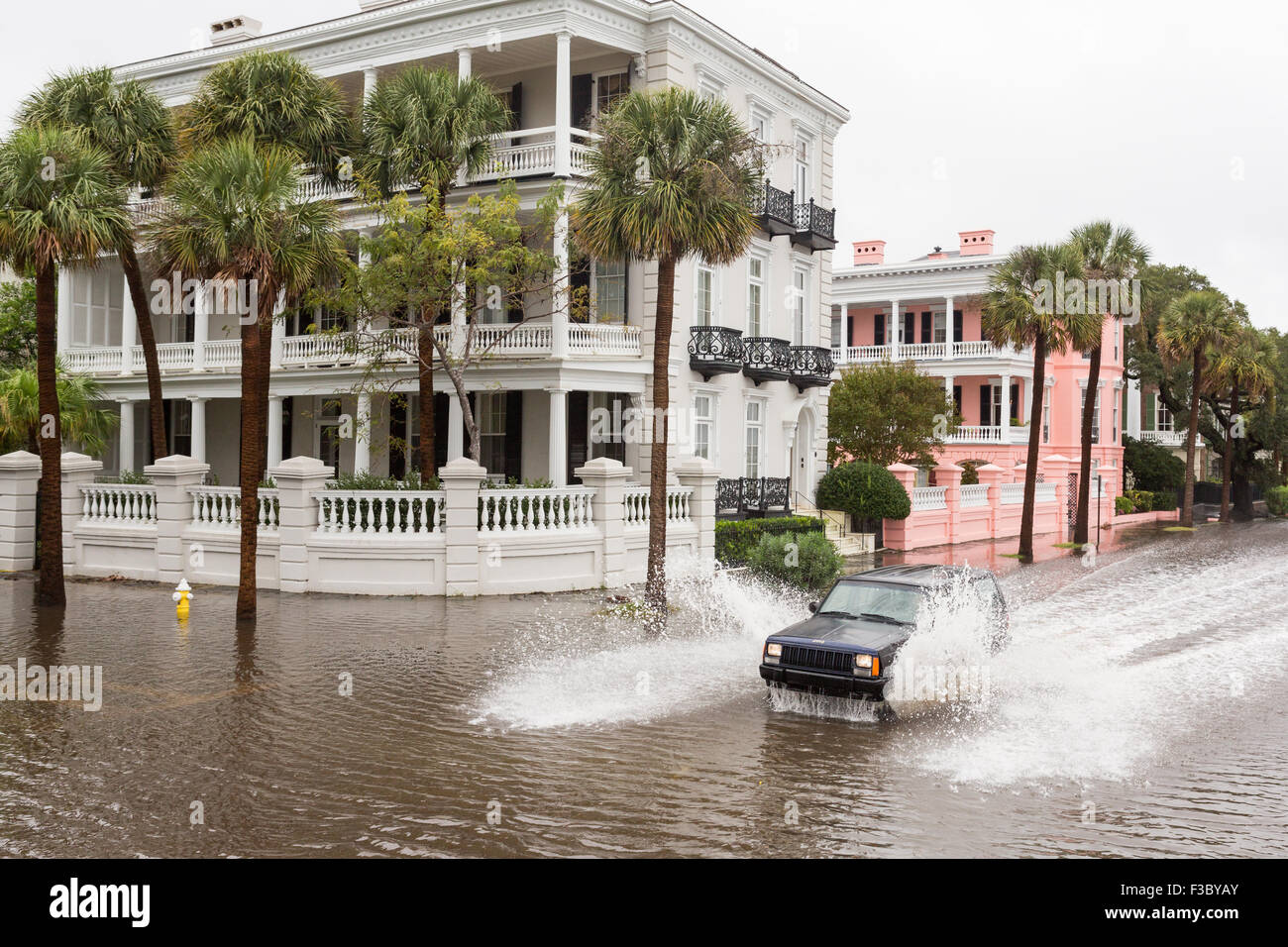 Charleston, Carolina del Sud, Stati Uniti d'America. 4 Ottobre, 2015. Macchine passano le case signorili in alluvioni lungo la batteria nel quartiere storico come l'uragano Joaquin provoca forti piogge, alluvioni e venti forti come passa offshore Ottobre 4, 2015 a Charleston, Carolina del Sud. Foto Stock