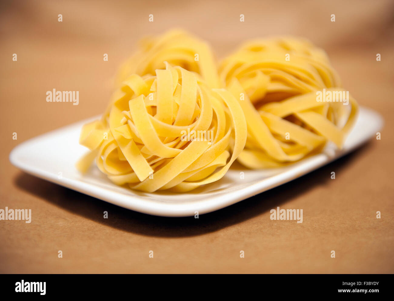 Vista ravvicinata di swirl pasta essiccata su una piastra bianca Foto Stock