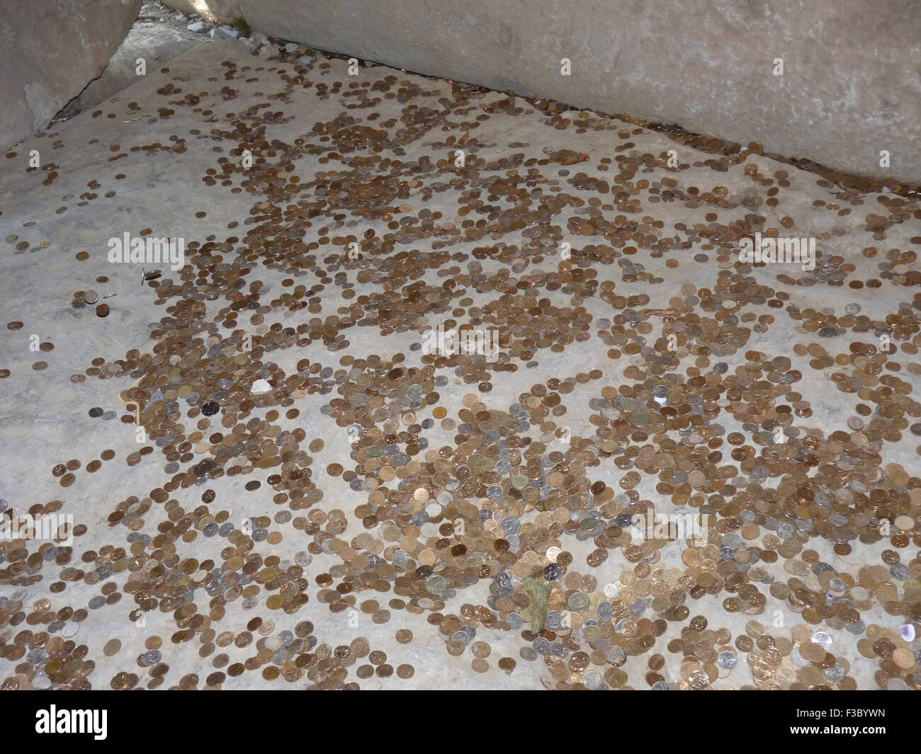 Monete su un pavimento di calcestruzzo. Gettare per fortuna e successo di  monete nel luogo santo Foto stock - Alamy
