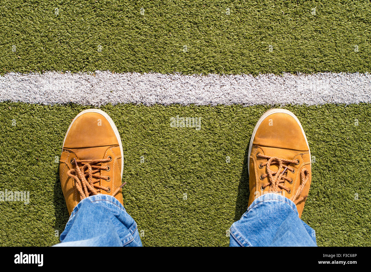 Vista superiore del maschio di sneakers in erba artificiale con la linea bianca Foto Stock