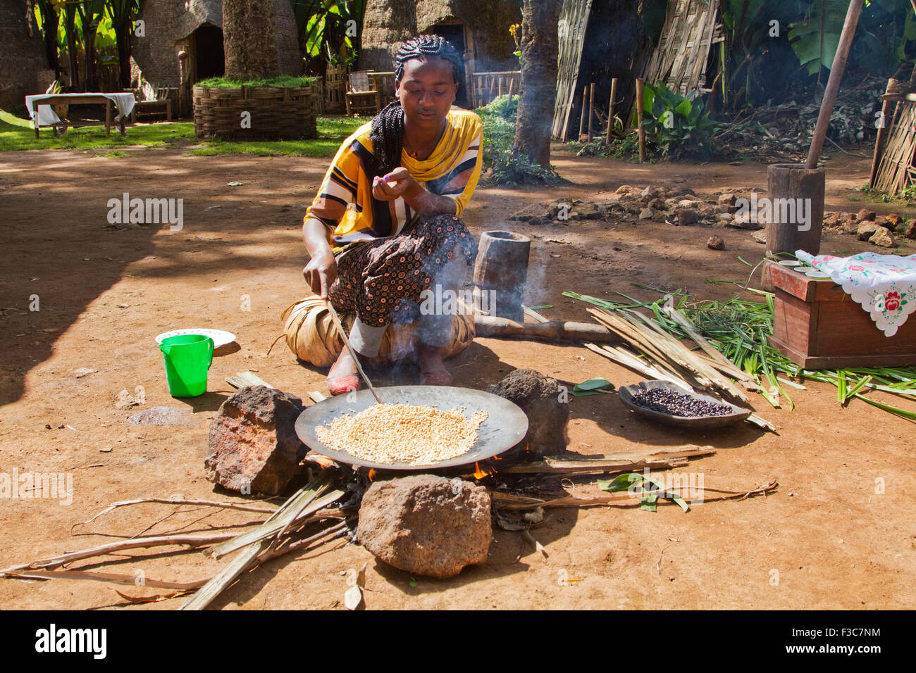 Donna Dorse arrosti i chicchi di caffè. Fotografato nella valle dell'Omo, Etiopia Foto Stock