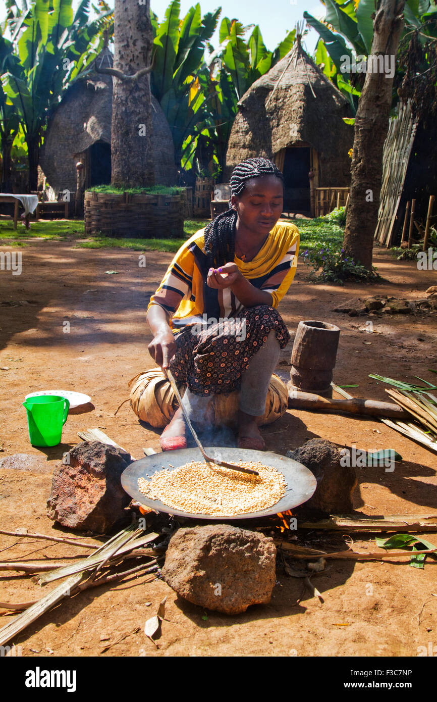 Donna Dorse arrosti i chicchi di caffè. Fotografato nella valle dell'Omo, Etiopia Foto Stock