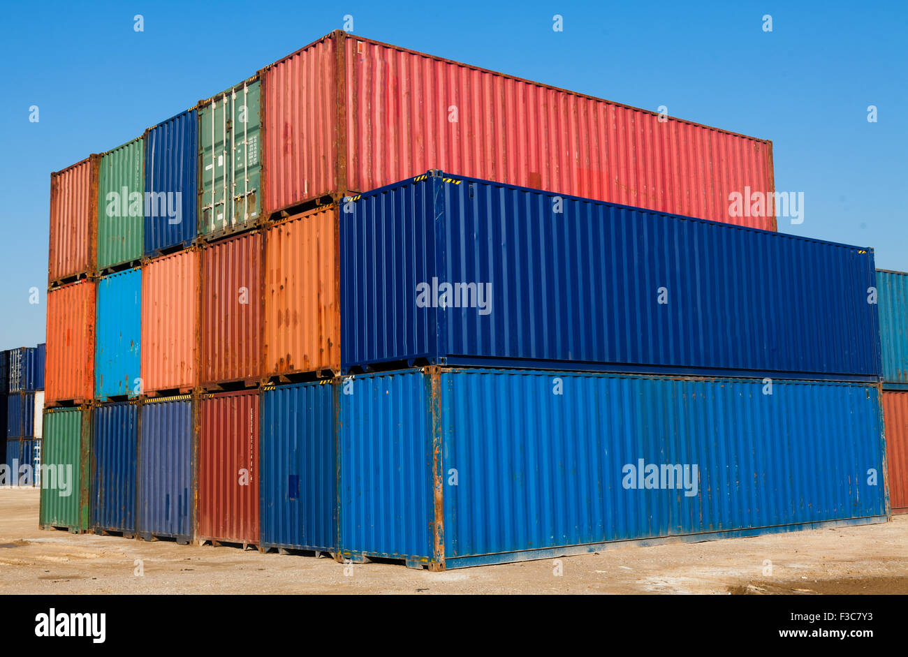 Colore sovrapposti ai contenitori di carico sotto il cielo blu Foto Stock