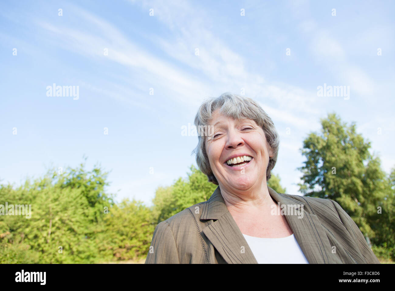 La vecchiaia donna sorridente al di fuori Foto Stock