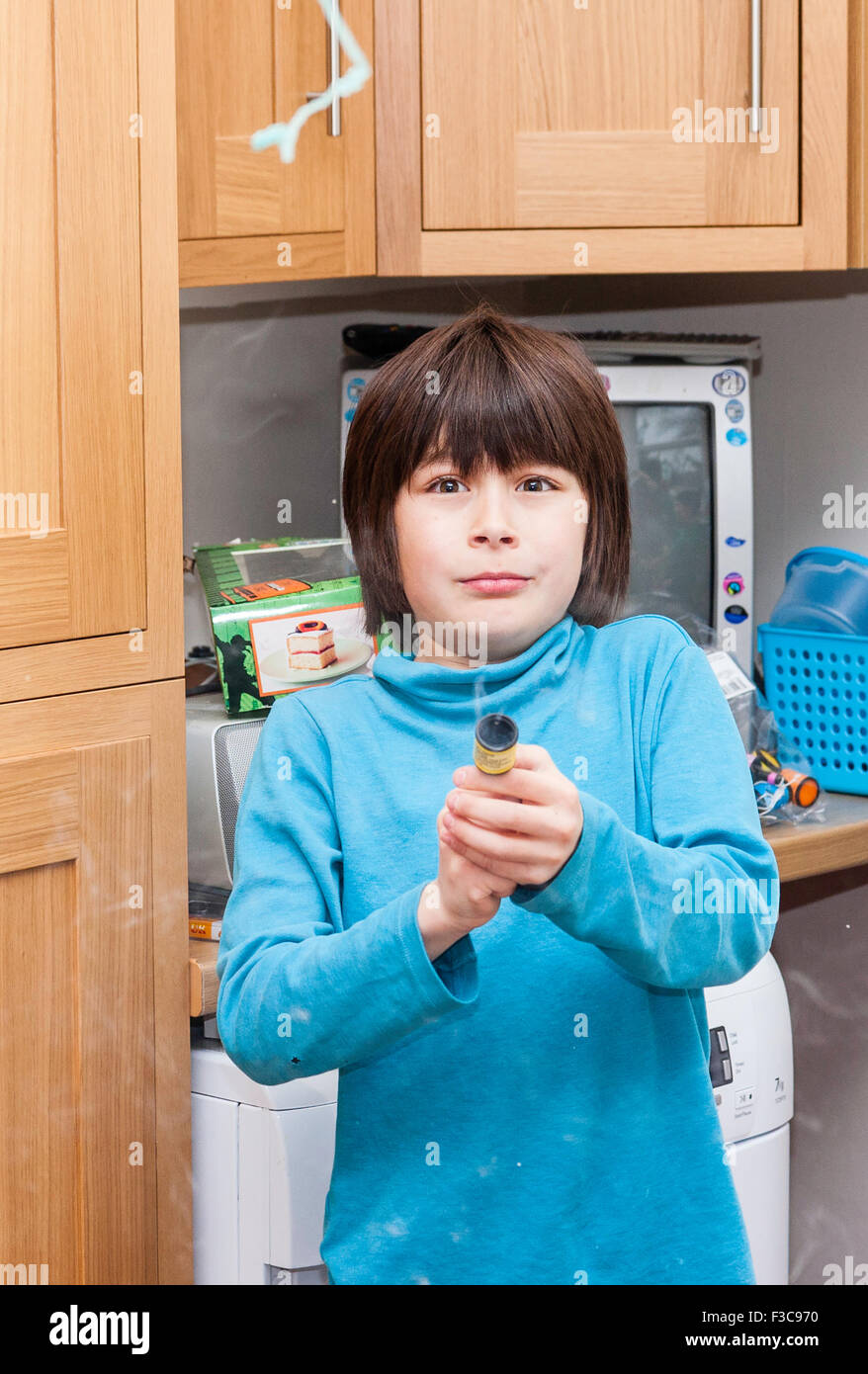 Etnia miste, giapponese (Inglese) 11 anno-vecchio ragazzo sparando party popper Foto Stock