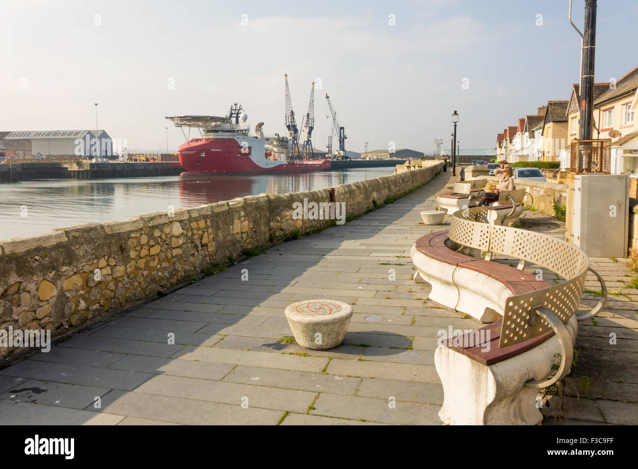 Posti a sedere pubbliche a Hartlepool Heugh promontorio che si affaccia sul porto di entrata e nave SIEM DAYA 1 Foto Stock