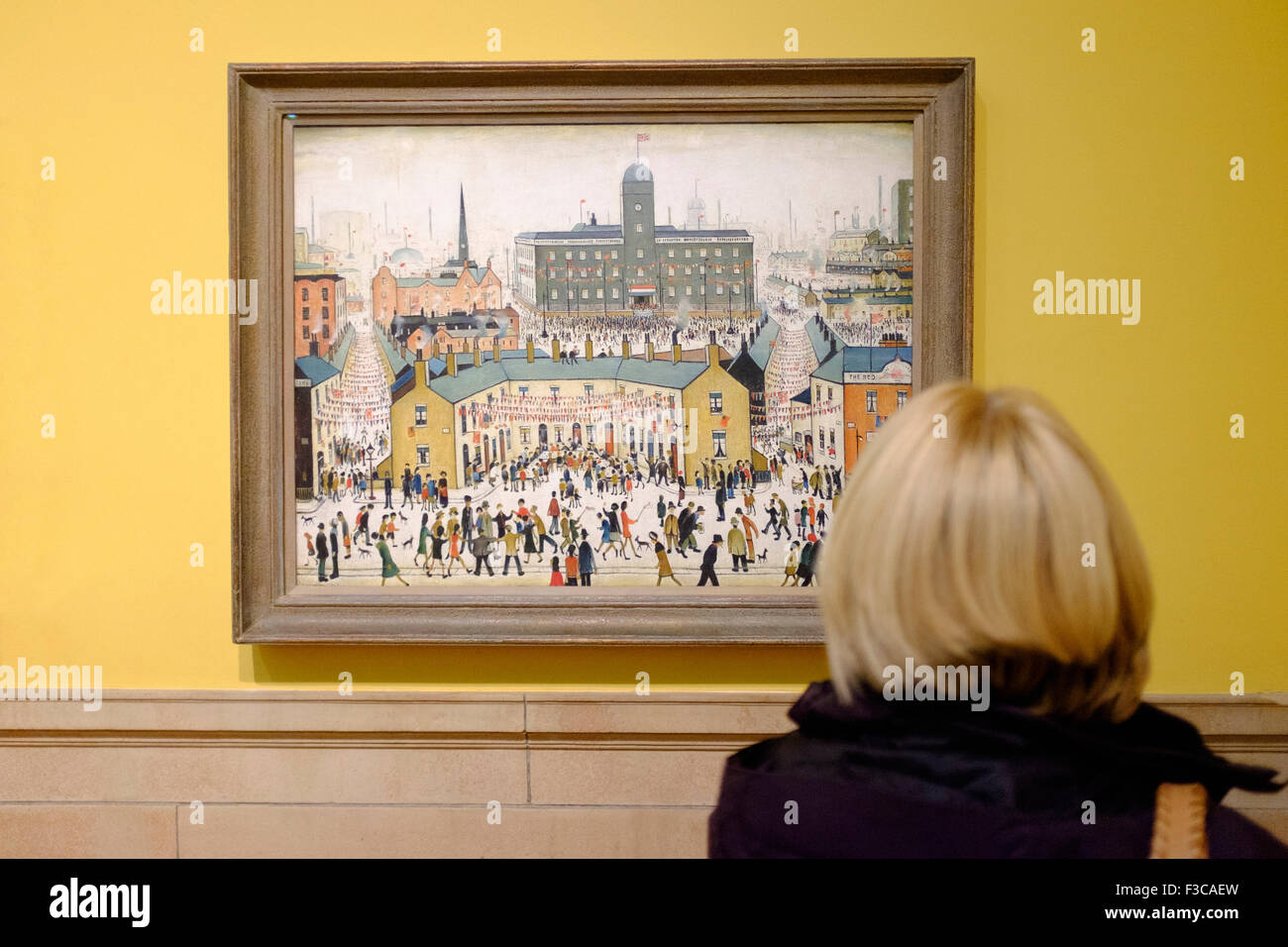 Visitatore in cerca di dipingere VE Giorno di LS Lowry sul display a Kelvingrove Art Gallery and Museum di Glasgow Regno Unito Foto Stock