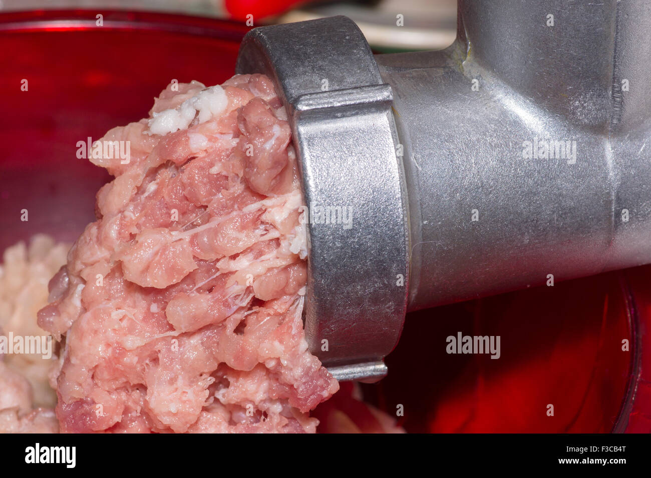 Preparazione di forcemeat fresca attraverso il tritacarne da fette di carne Foto Stock