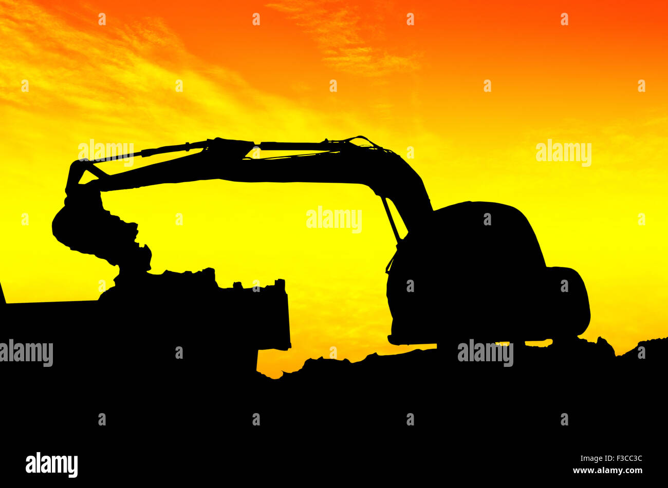 Silhouette caricamento escavatore dumper ribaltabile in buca di sabbia sul tramonto Foto Stock