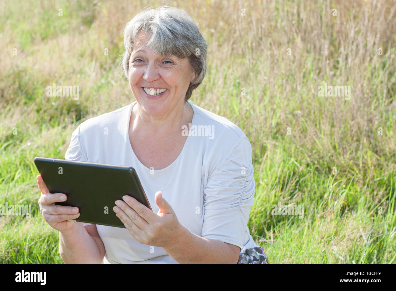 Senior donna utilizzando dispositivo tablet pc Foto Stock