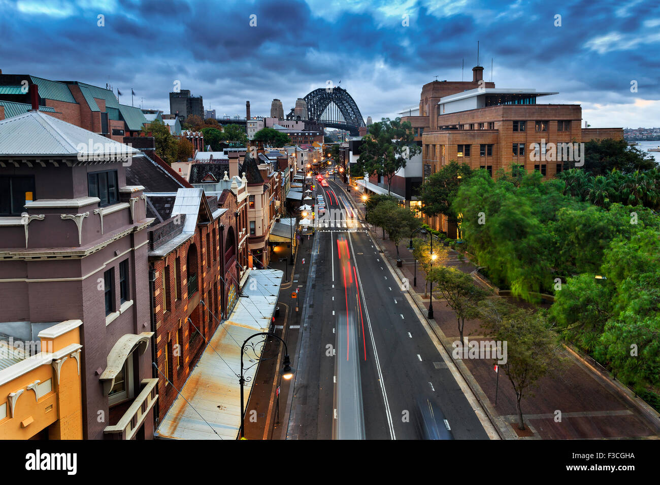 Sydney è la Roccia storico quartiere residenziale del borgo e al tramonto dalla suddetta posizione con le luci accese e Harbour Bridge Foto Stock