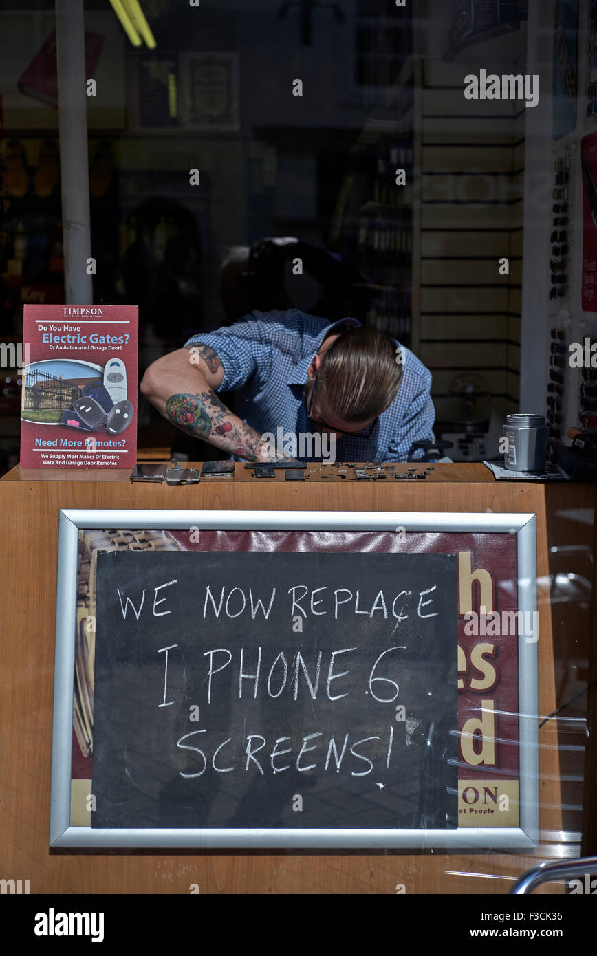 Negozio di riparazione iPhone. Finestra che fa pubblicità a un servizio di sostituzione dello schermo di iPhone 6 che è un problema comune per i proprietari. Foto Stock