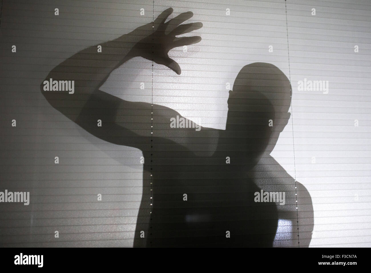 Silhouette di uomo spy il peering attraverso la finestra Foto Stock