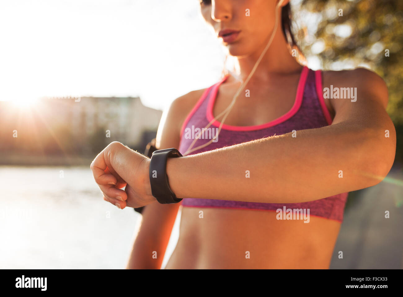 Giovane donna fitness guardando il suo orologio intelligente mentre prendendo una pausa da allenamento all'aperto. Controllo Sportwoman impulso su idoneità s Foto Stock