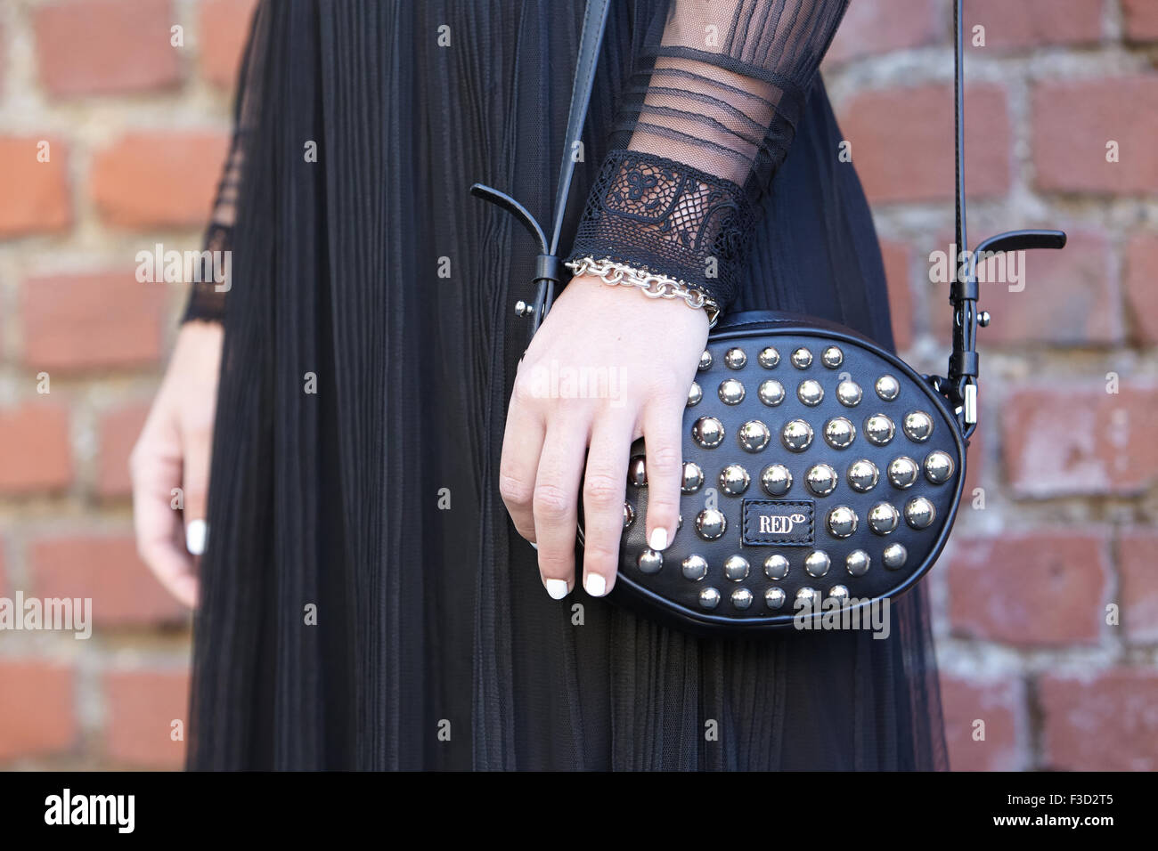 La donna pone per i fotografi prima di Fendi show con nero rosso Valentino sacchetto durante la settimana della moda milanese giorno Foto Stock