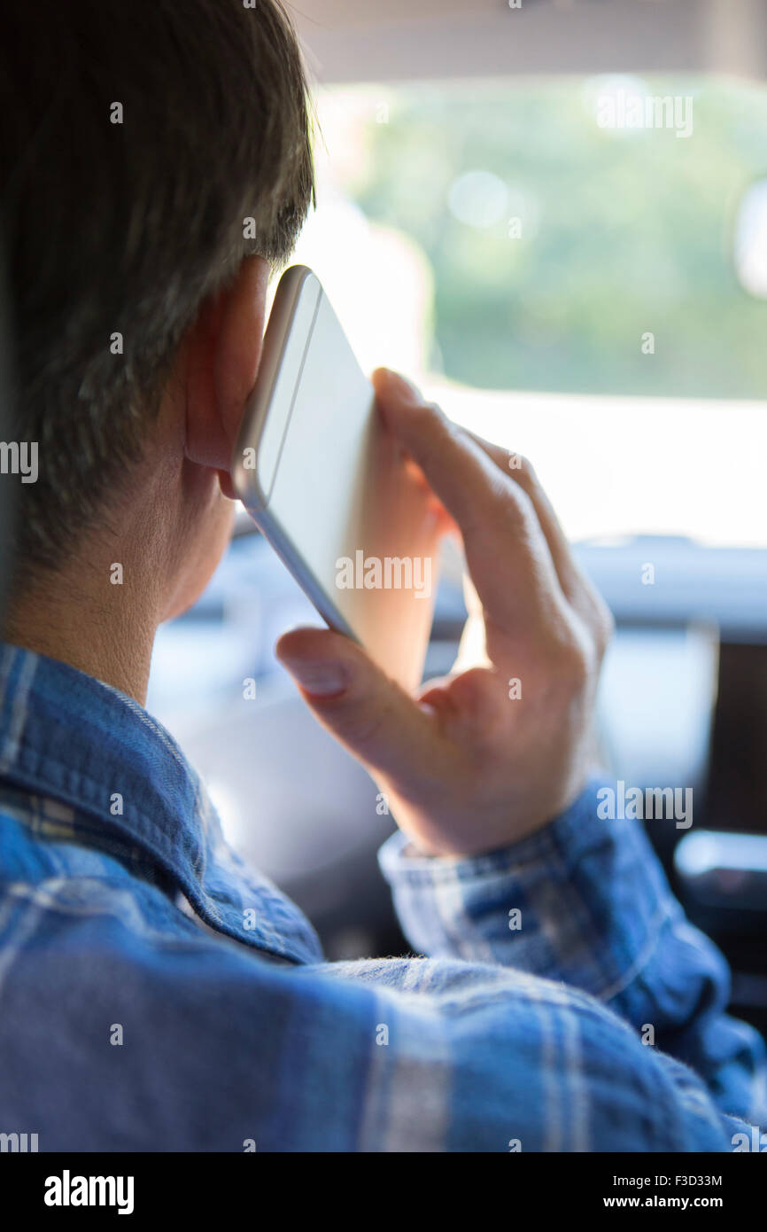 Uomo in auto parlando al telefono cellulare durante la guida Foto Stock