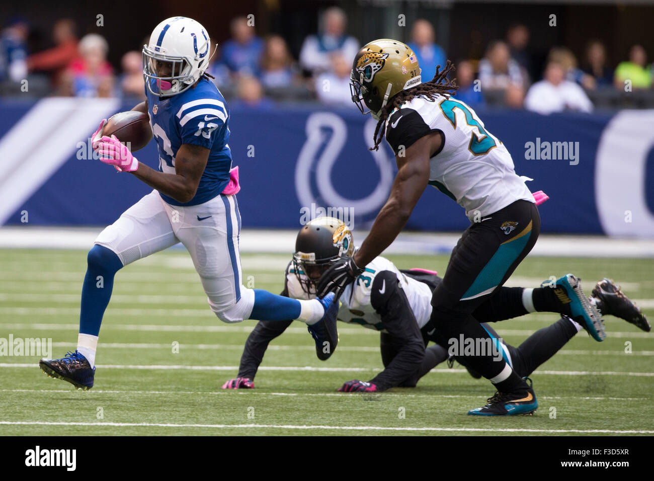 Le ore di lavoro straordinario. 4 Ott 2015. Indianapolis Colts wide receiver T.Y. Hilton (13) corre via con la sfera da Jacksonville Jaguars cornerback Davon House (31) e di forte sicurezza Johnathan Cyprien (37) durante il gioco di NFL tra Jacksonville Jaguars e Indianapolis Colts a Lucas Oil Stadium di Indianapolis, Indiana. La Indianapolis Colts ha vinto in 16-13 ore di lavoro straordinario. Christopher Szagola/CSM/Alamy Live News Foto Stock