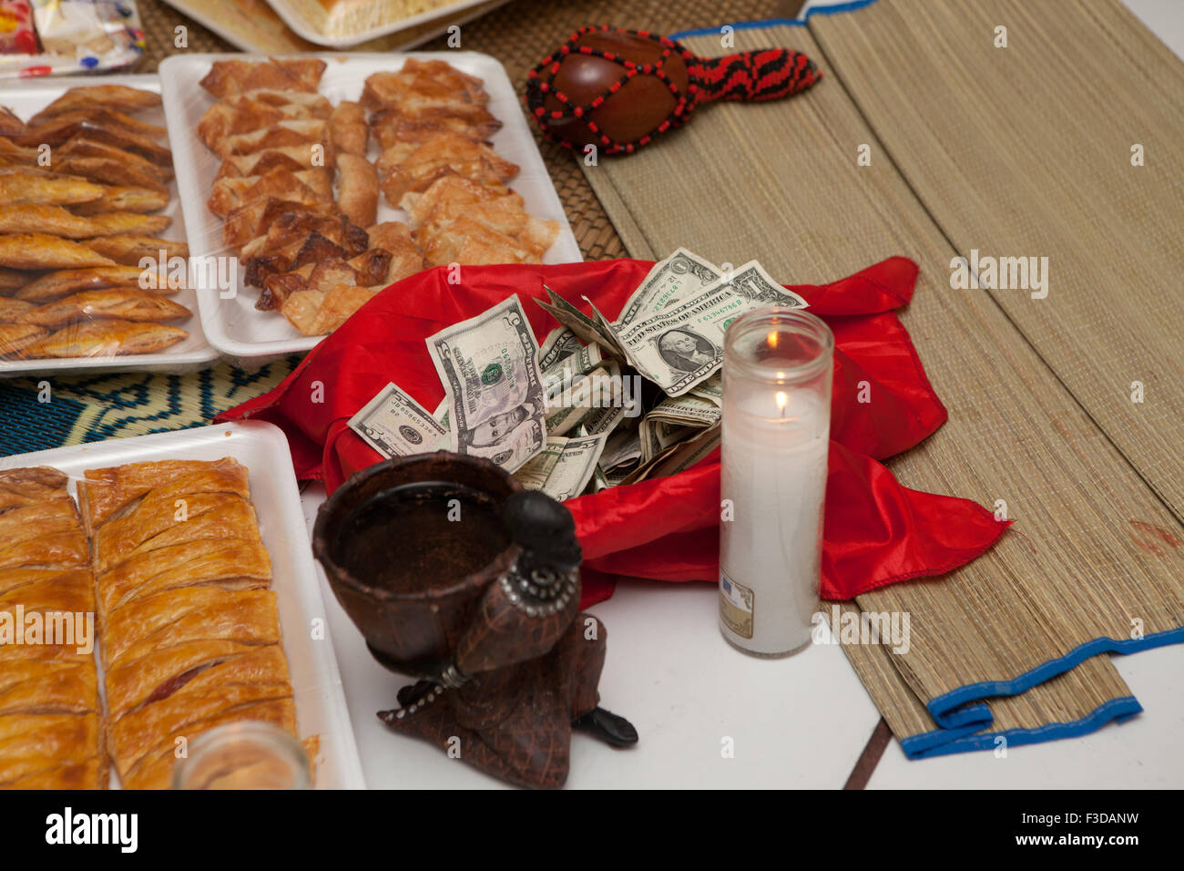 Offerta religiosa Santeria Orula Babalawo denaro, candela, guaiava pastello, Pastelito cubano Foto Stock