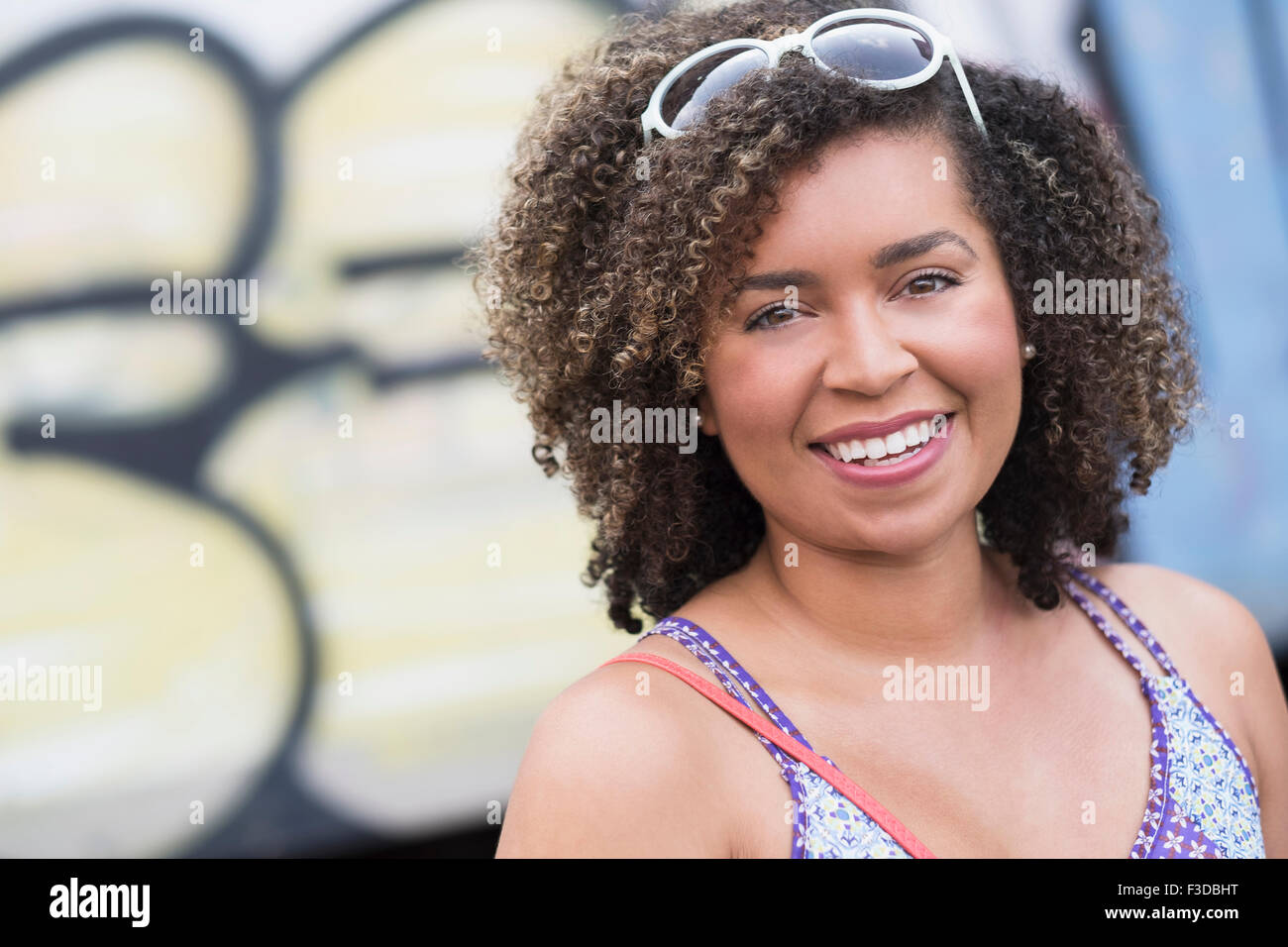 Ritratto di sorridente giovane donna con capelli ricci Foto Stock