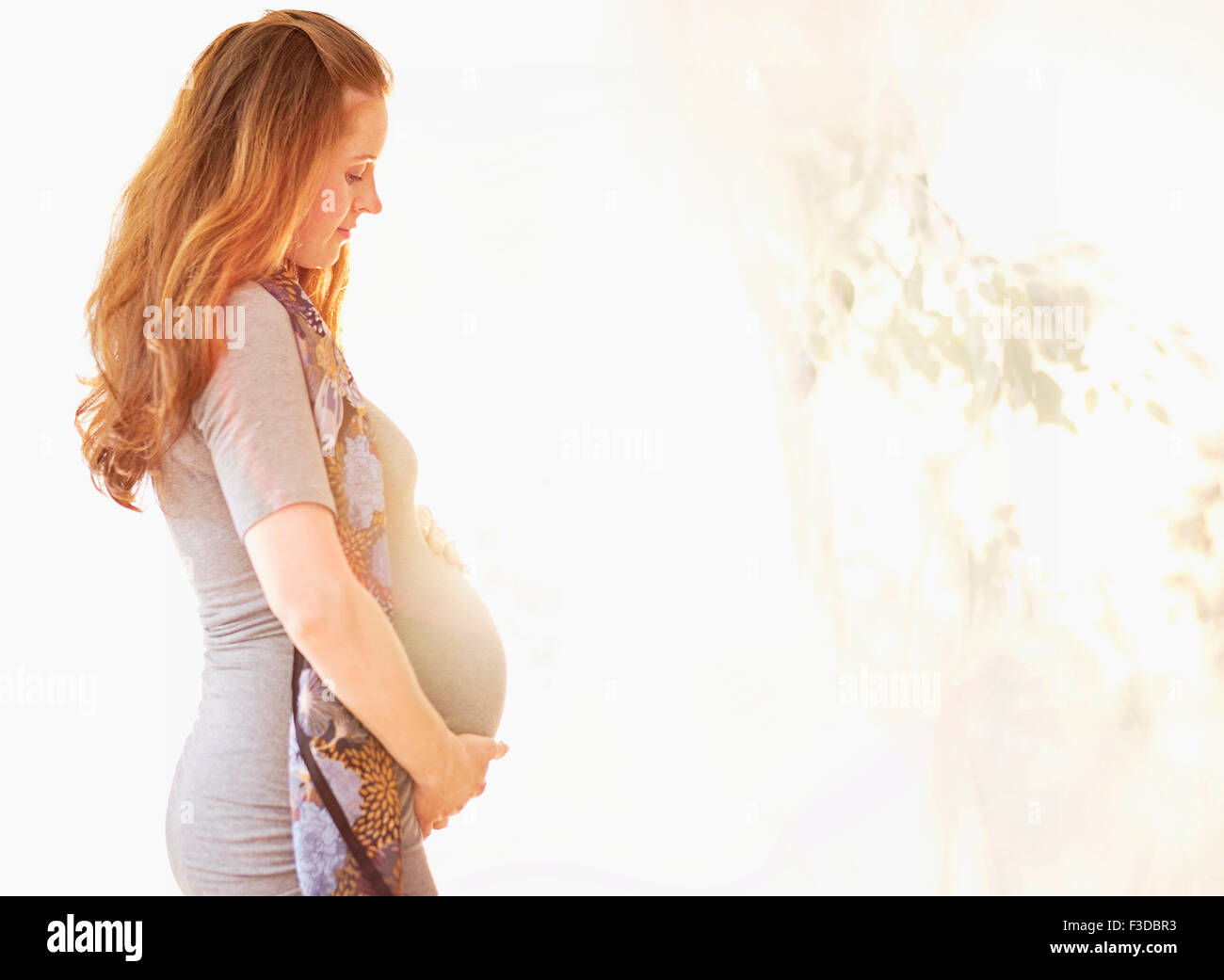 Vista laterale della donna incinta all'aperto Foto Stock