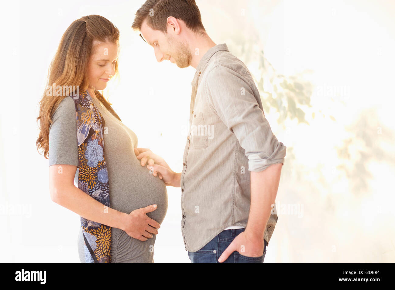 Donna incinta tenendo le mani con il suo fidanzato Foto Stock