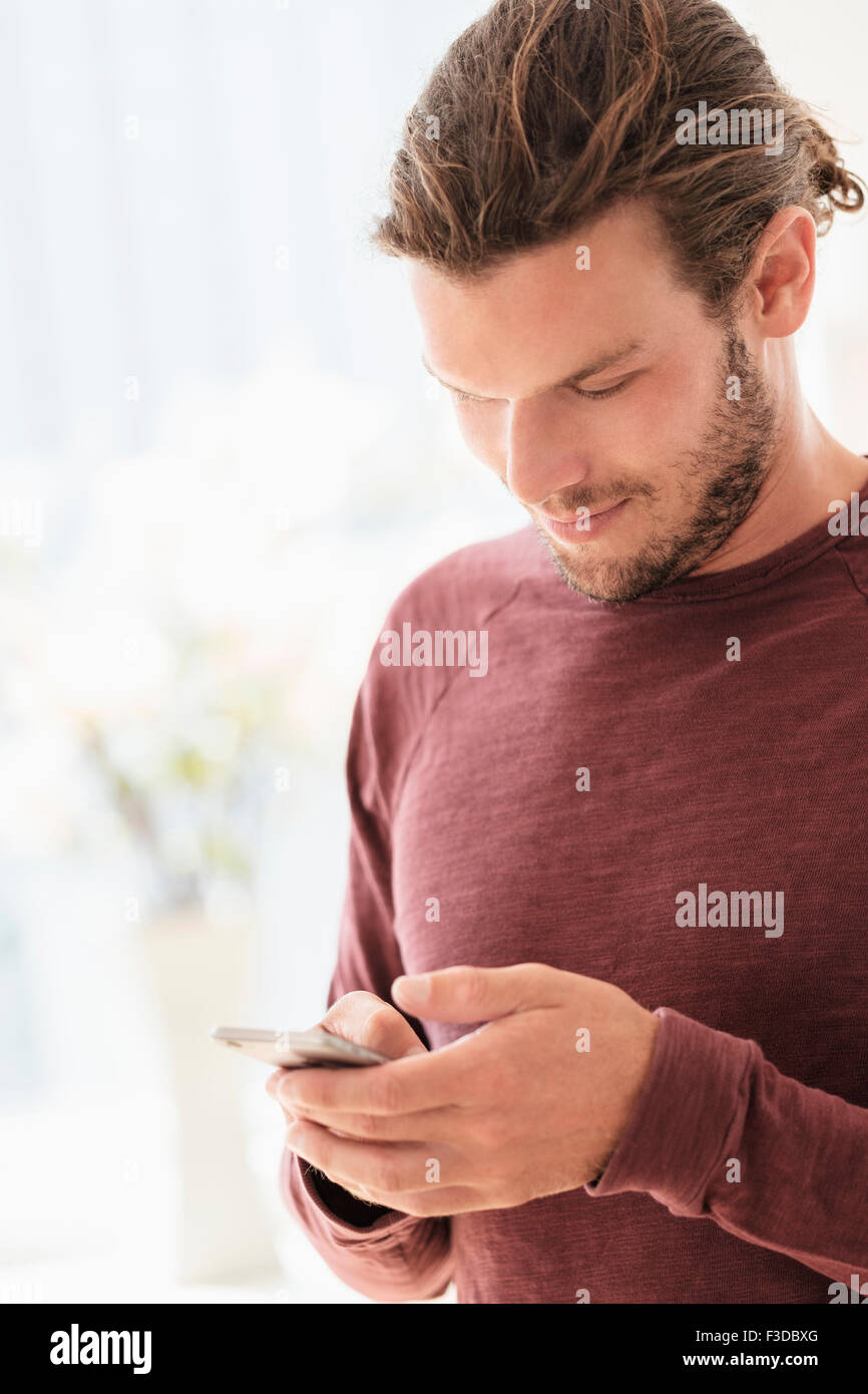 Metà di uomo adulto texting in ambienti interni Foto Stock