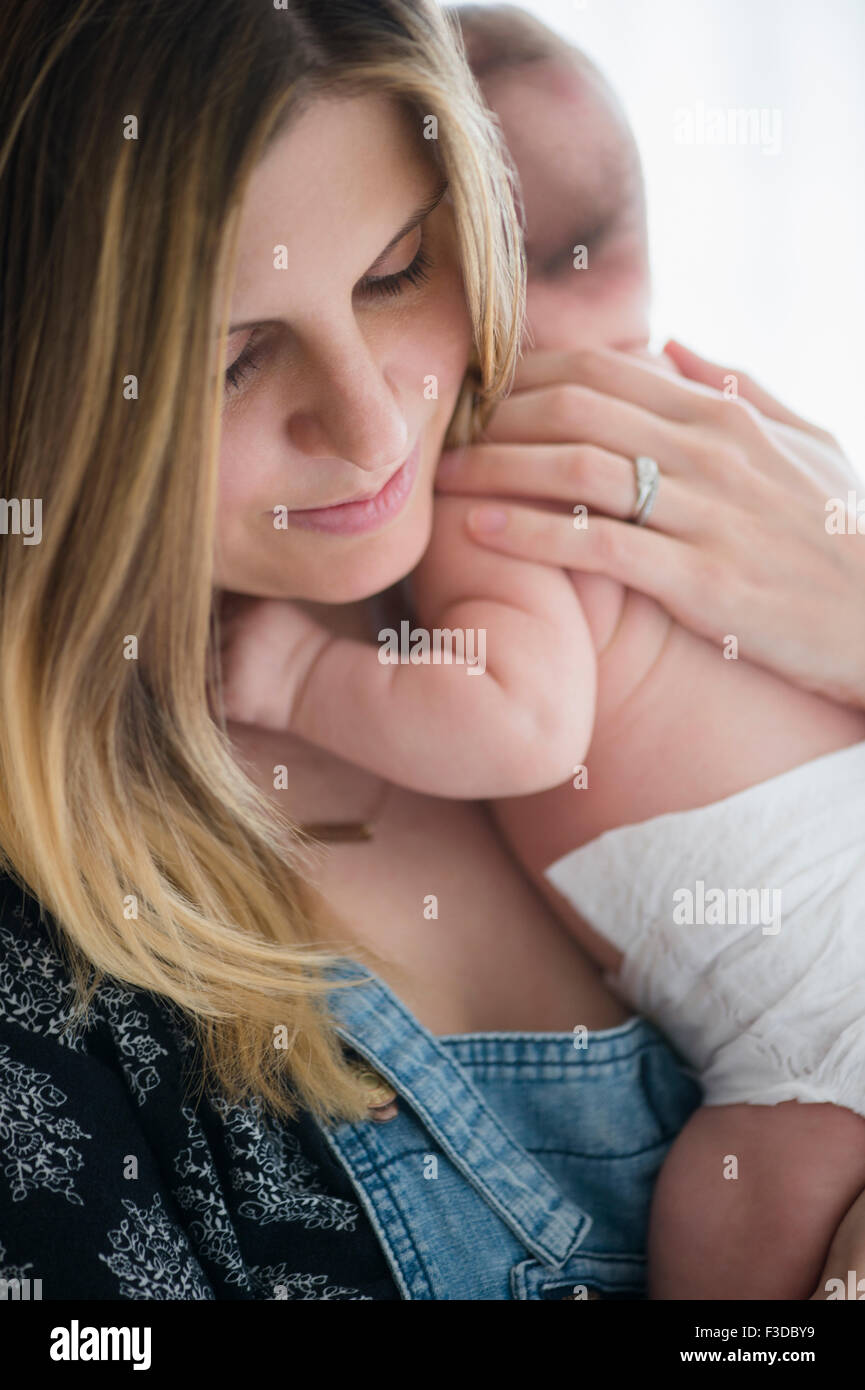 Azienda madre bambina (2-5 mesi) nelle sue braccia Foto Stock