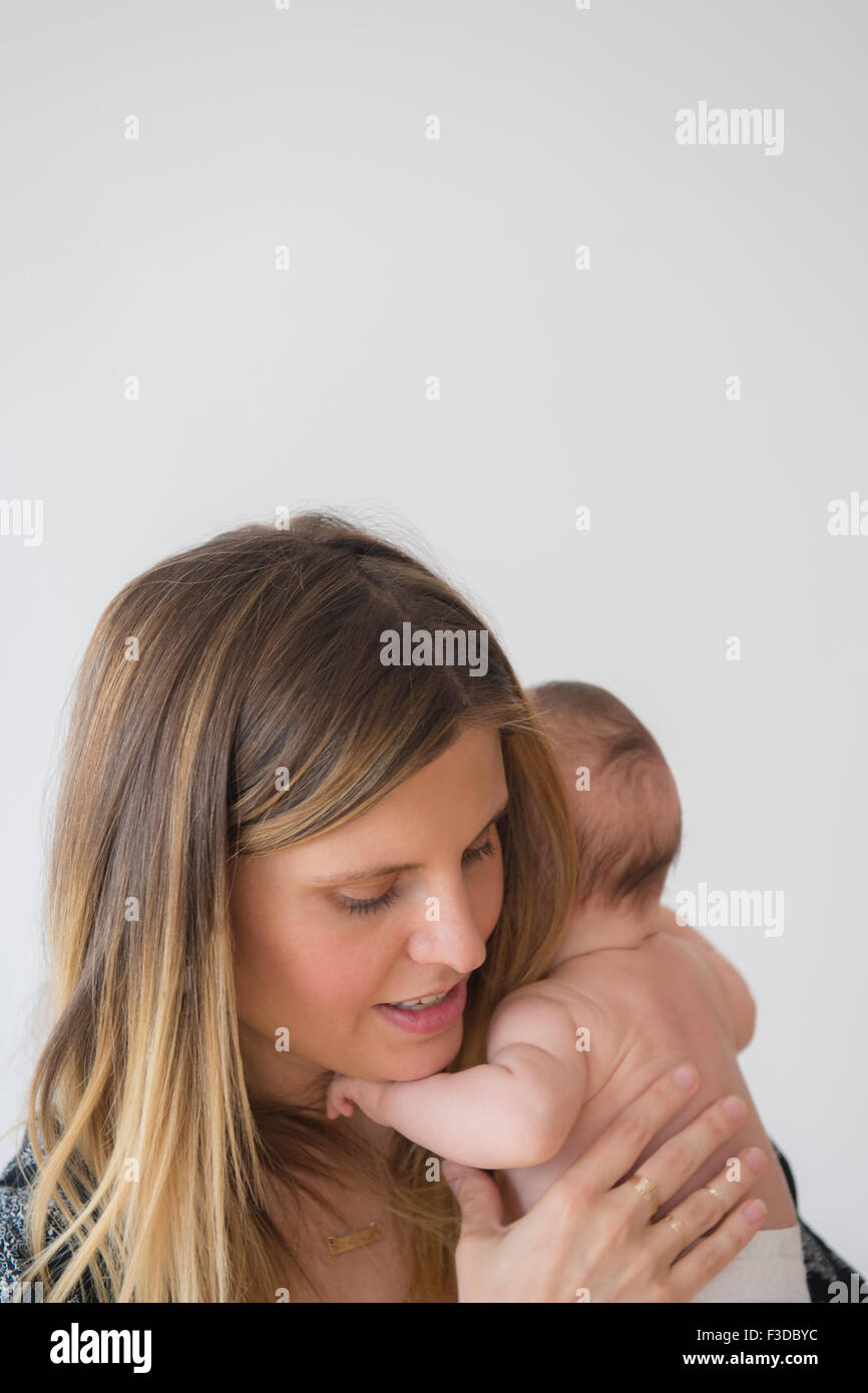 Azienda madre bambina (2-5 mesi) nelle sue braccia Foto Stock