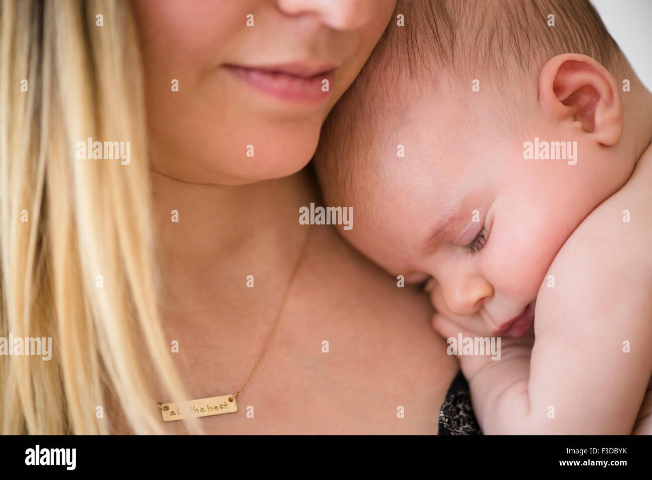 Baby girl (2-5 mesi) di dormire sulla madre di spallamento Foto Stock