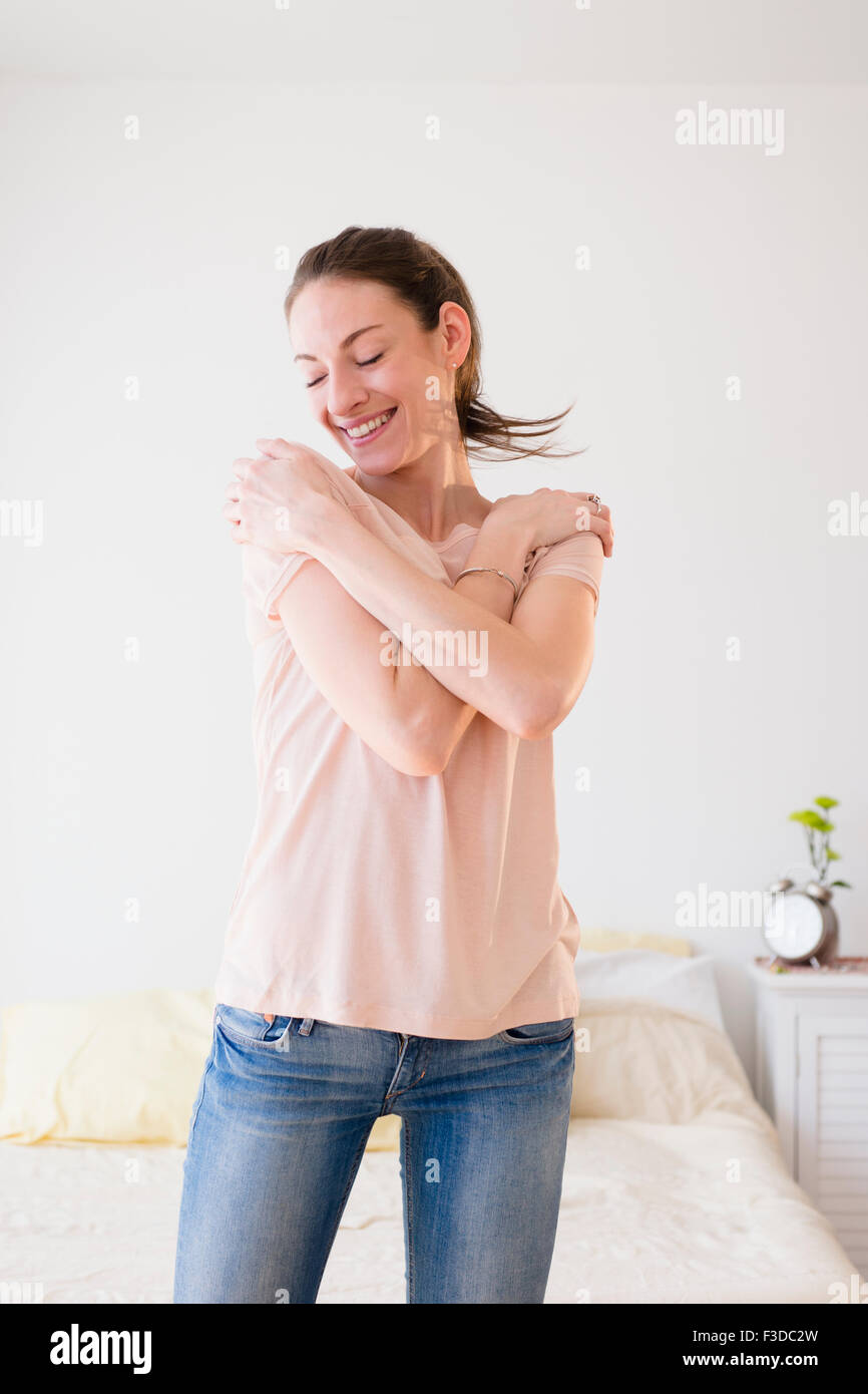 Donna sorridente in camera da letto Foto Stock