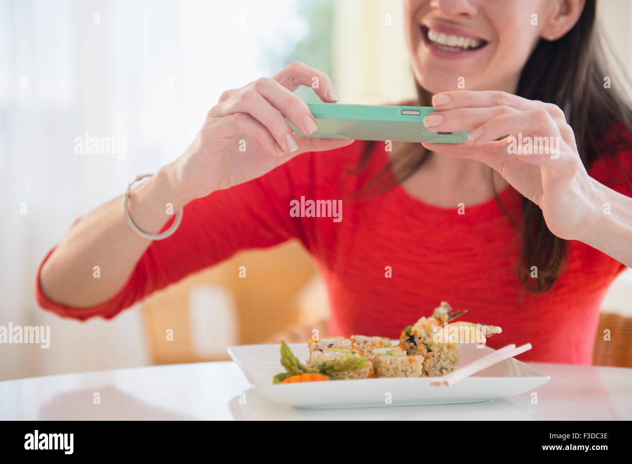 La donna sta immagine di pasto con lo smartphone Foto Stock