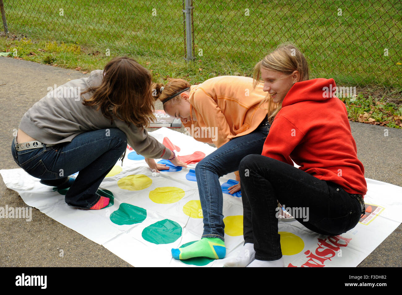 Teen e pre-teen ragazze giocando Twister Gioco del pavimento. Foto Stock