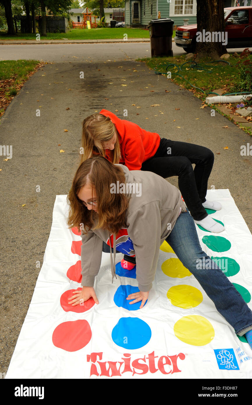 Teen e pre-teen ragazze giocando Twister Gioco del pavimento. Foto Stock