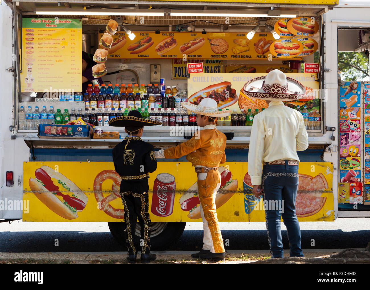 Mexican-American ragazzi in abiti vaquero e sombreros in piedi di fronte a hot dog food carrello - Washington DC, Stati Uniti d'America Foto Stock