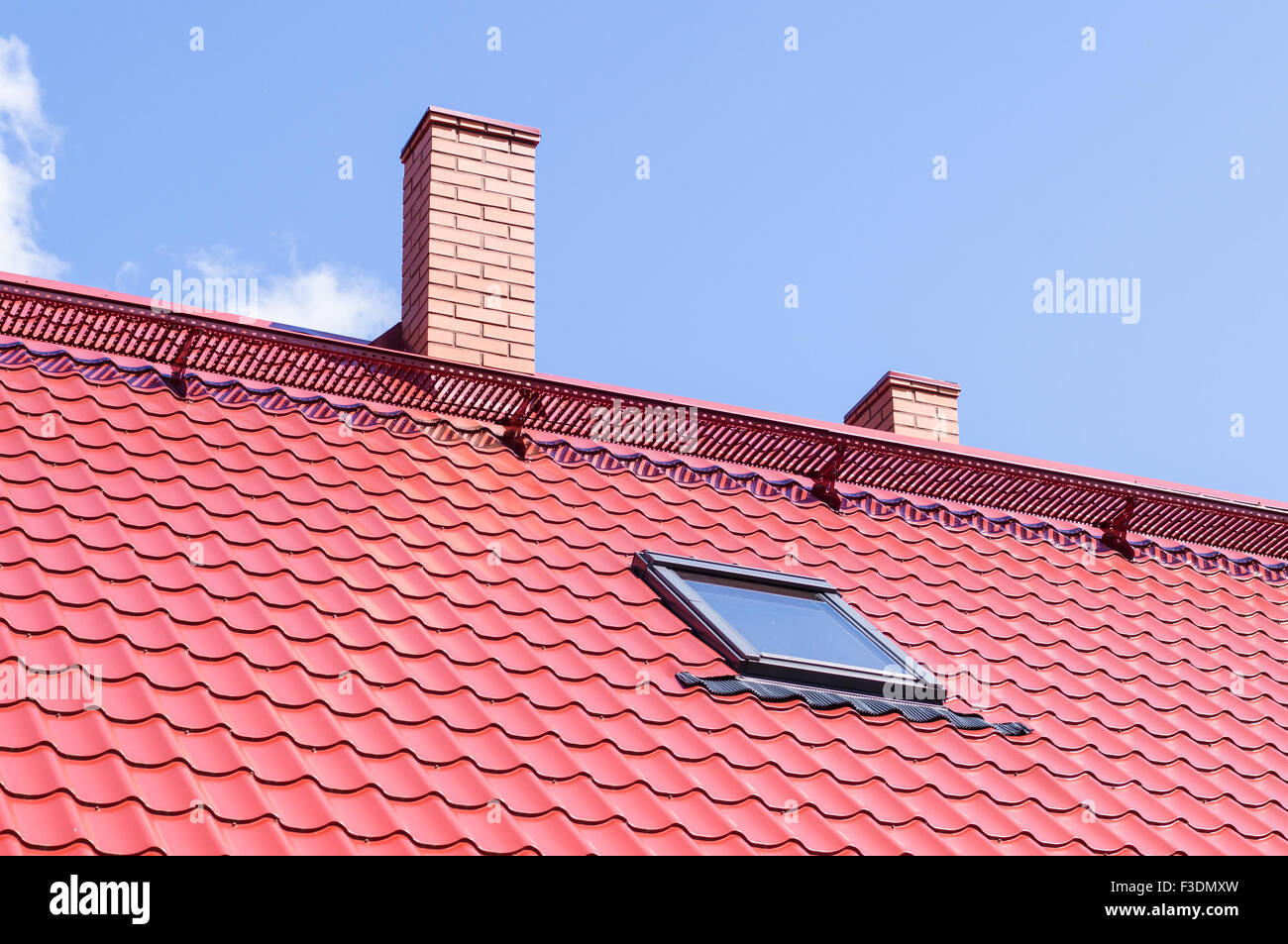 Ciminiera in mattoni sul tetto rosso con Finestra mansarda Foto Stock