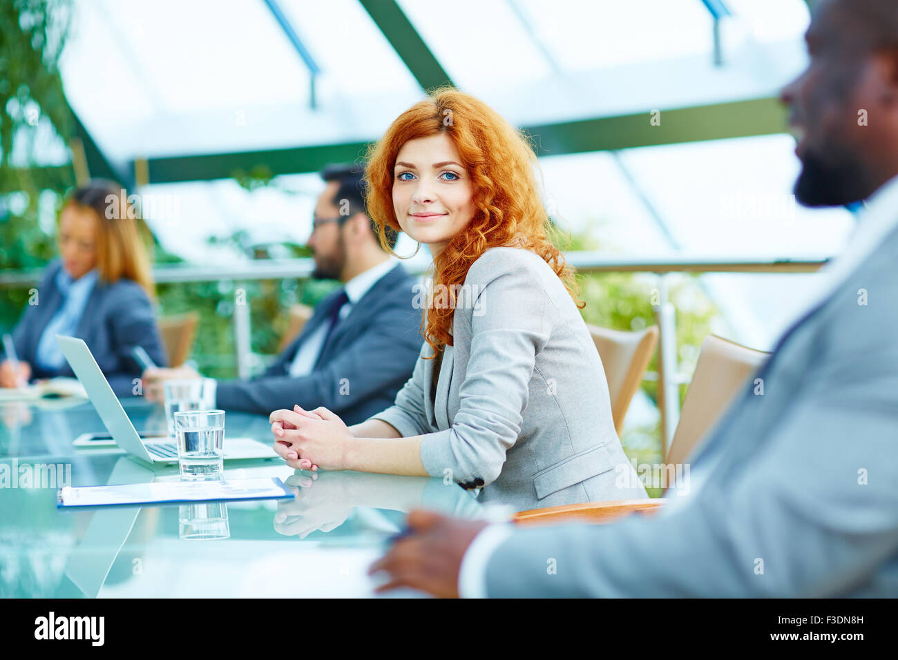 Piuttosto giovane imprenditrice guardando telecamera durante la lezione Foto Stock
