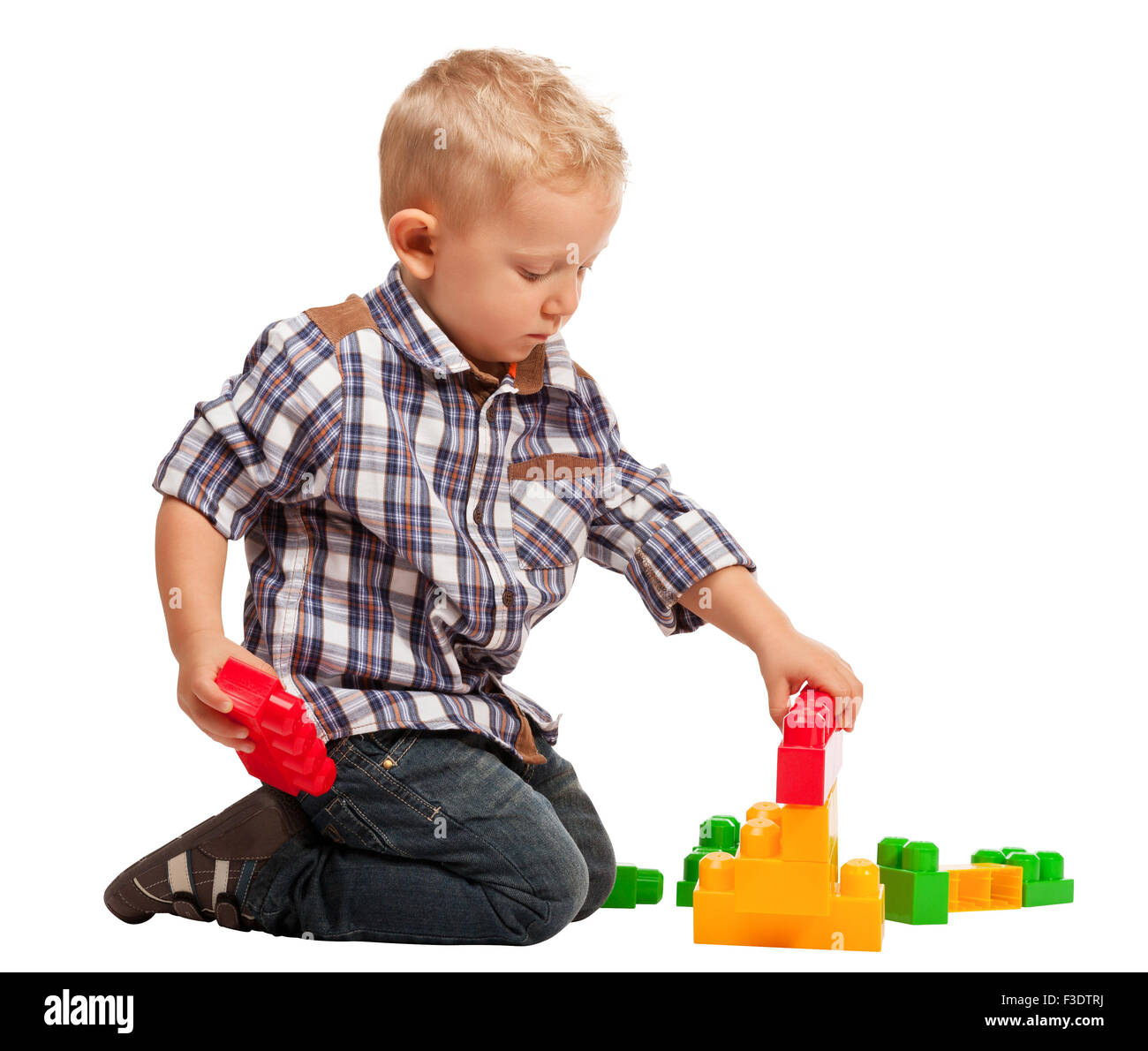 Il bambino gioca con la costruzione di blocchi di giocattolo isolato su bianco Foto Stock