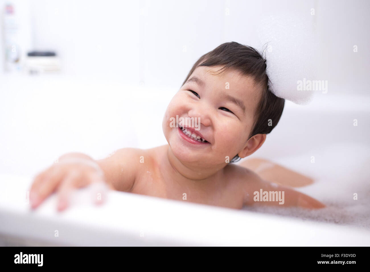 Baby boy godendo un bagno di bolle, ritratto Foto Stock