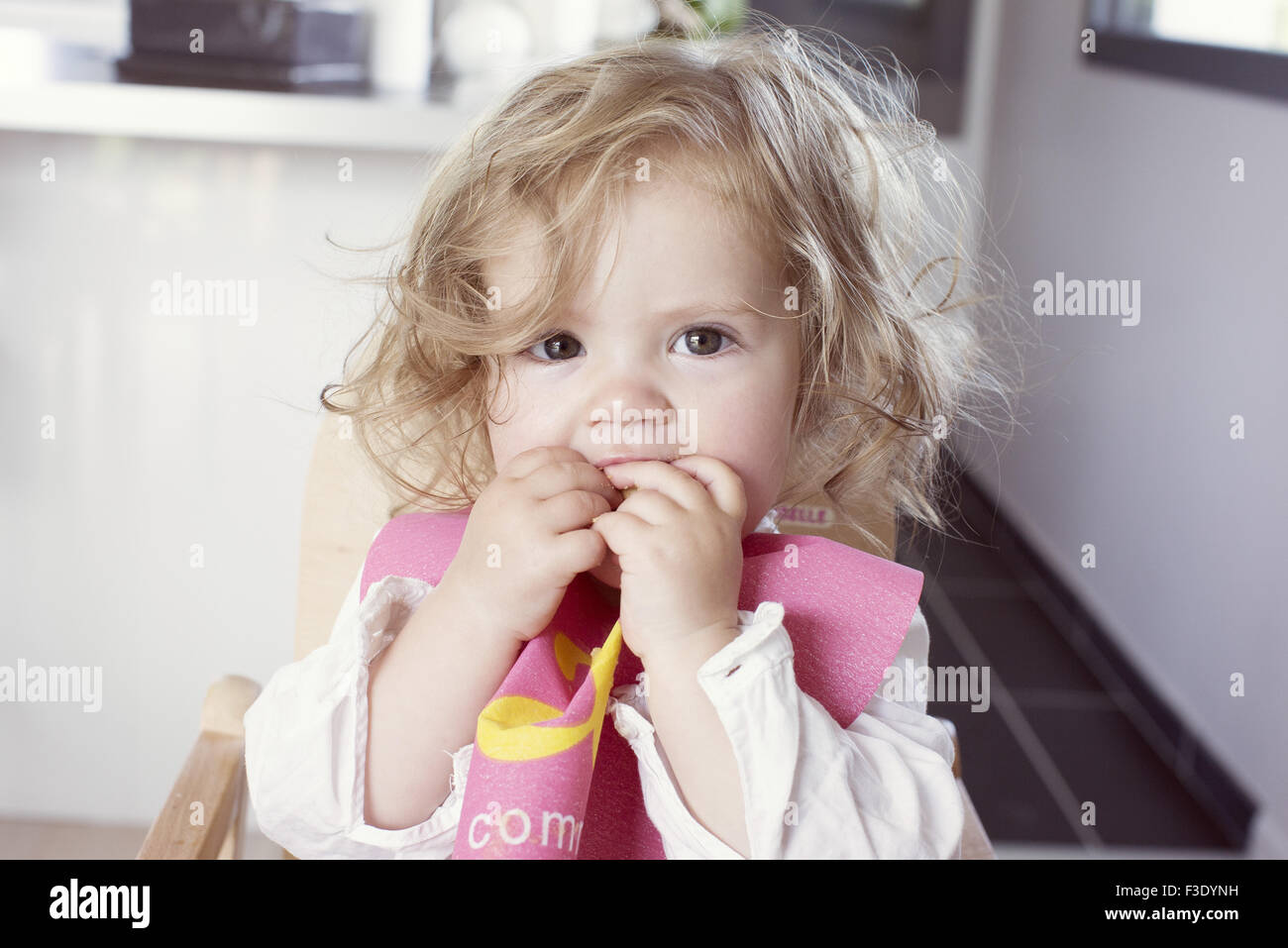 Baby girl mangiando snack, ritratto Foto Stock