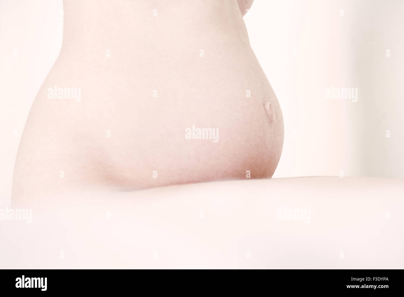 Della donna incinta, stomaco nudo, vista laterale Foto Stock