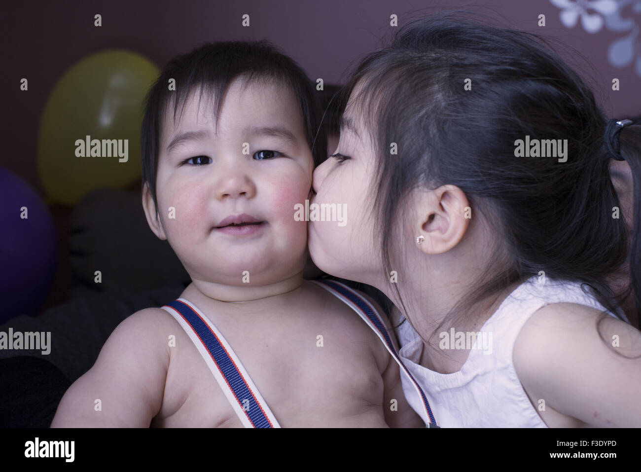 Piccola ragazza baciare fratellino sulla guancia, ritratto Foto Stock