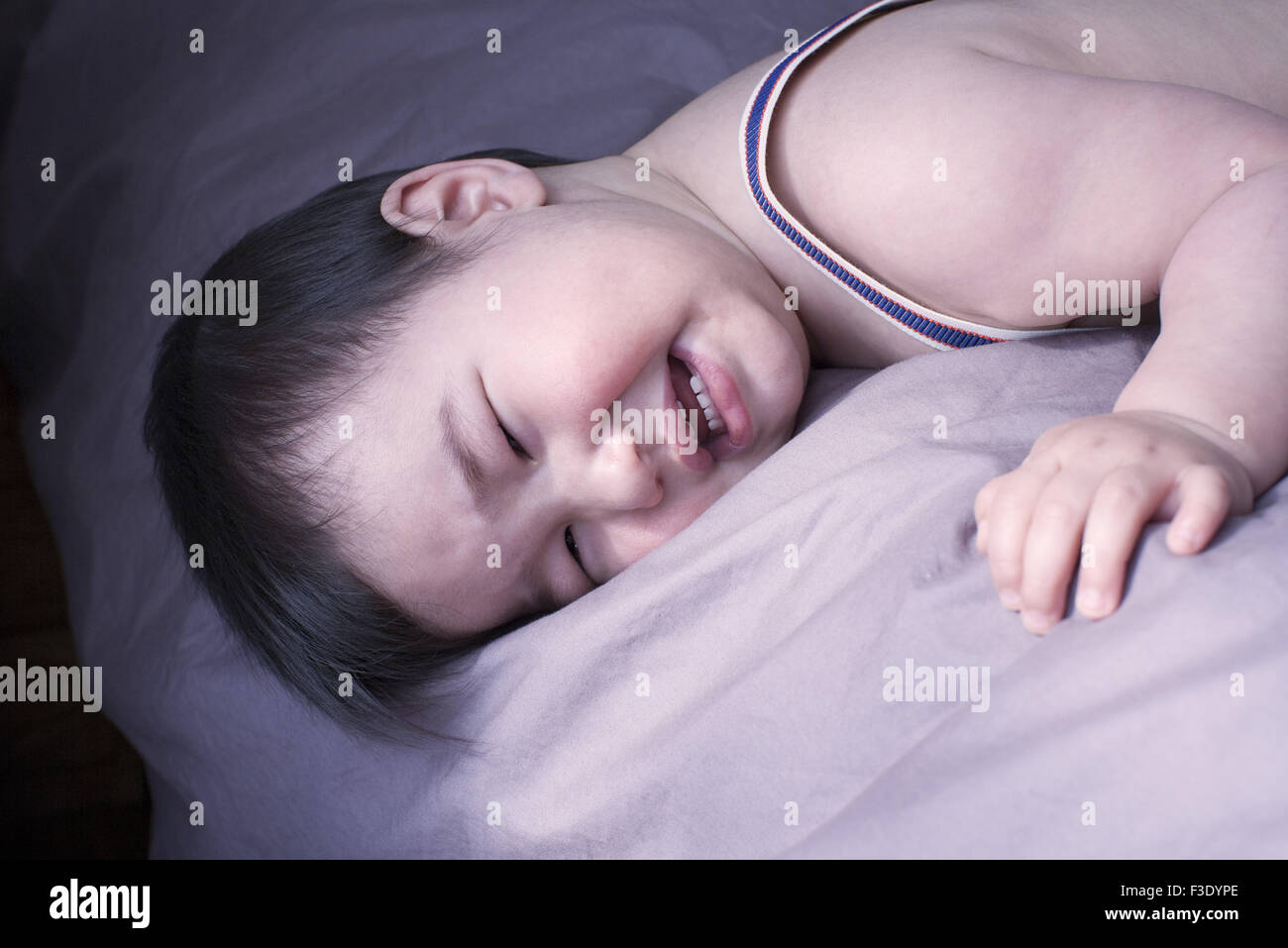 Baby boy a piangere sul letto Foto Stock
